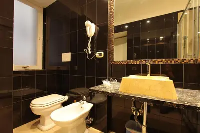 a black bathroom with a toilet and a sink at VIA VENETO SUITE 104 in Rome