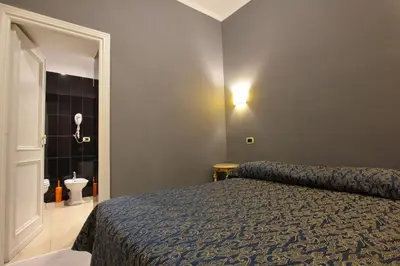 a bedroom with a bed and a bathroom with a toilet at VIA VENETO SUITE 104 in Rome
