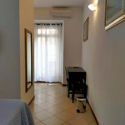a bedroom with a table and a bed and a desk at B&B Missi in Rome