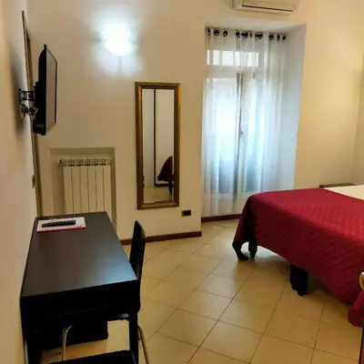 a room with a bed and a table and a mirror at B&B Missi in Rome