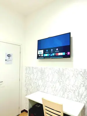 a flat screen tv on a wall with a table at Tawhid Accomodation in Rome