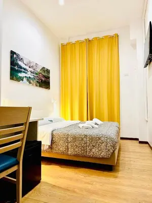 a bedroom with a bed and a yellow curtain at Tawhid Accomodation in Rome