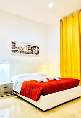 a bedroom with a bed and a yellow curtain at Tawhid Accomodation in Rome