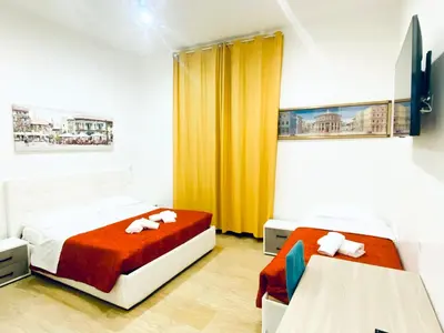 two beds in a room with yellow curtains at Tawhid Accomodation in Rome