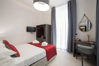a bedroom with a bed and a desk and a mirror at Bespoke Roma Suites in Rome
