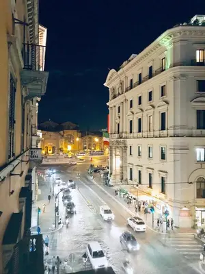 a busy city street at night with cars and buildings at Bespoke Roma Suites in Rome