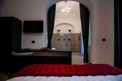 a bedroom with a red bed with a desk and a window at Bespoke Roma Suites in Rome