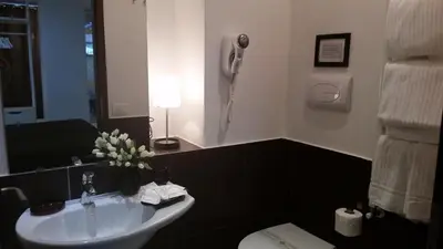 a bathroom with a sink and a toilet and a phone at InnVatican Guest House in Rome
