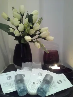 a table with a vase of flowers and a candle at InnVatican Guest House in Rome
