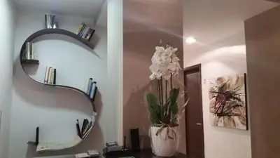 a bathroom with a mirror and a vase with white flowers at InnVatican Guest House in Rome