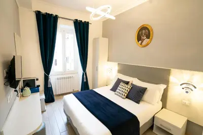 a bedroom with a large bed with blue curtains at Archi di Roma Guest House in Rome