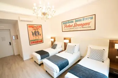 a hotel room with two beds and a chandelier at Archi di Roma Guest House in Rome