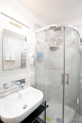a white bathroom with a sink and a shower at Archi di Roma Guest House in Rome