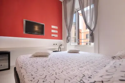 a bedroom with a bed and a tv on a red wall at Manin Suites LT in Rome