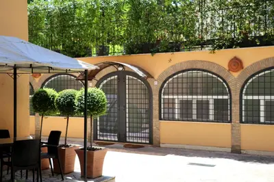 a patio with arches and a table and chairs at Villa Matissa Apartments in Rome