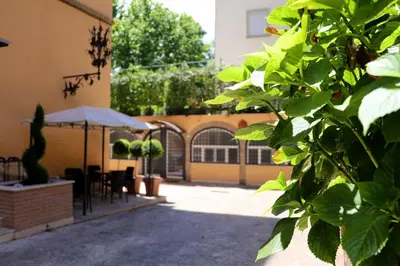 a courtyard with a table and chairs and an umbrella at Villa Matissa Apartments in Rome