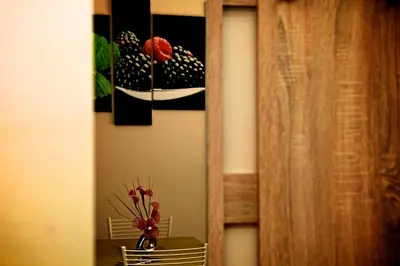 a vase of flowers on a table with a painting at Villa Matissa Apartments in Rome