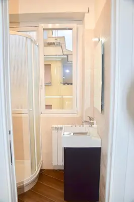 a bathroom with a sink and a large window at Terrazza San Giovanni apartment in Rome