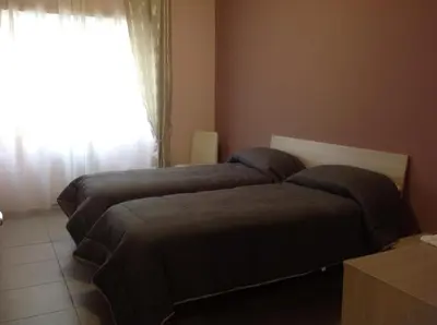 two beds in a room with a window at A casa di Armando in Rome