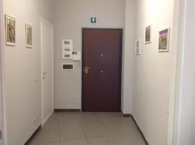a hallway with a brown door and pictures on the walls at A casa di Armando in Rome