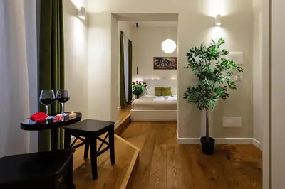 a living room with a couch and a table with a plant at Tula Inn in Rome