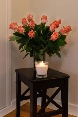 a black table with a candle and a vase of roses at Tula Inn in Rome