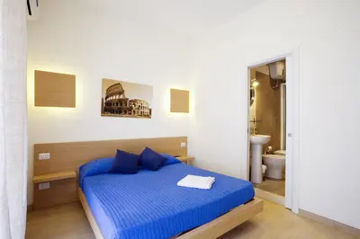 a bedroom with a blue bed and a bathroom at Affittacamere Nansen in Rome