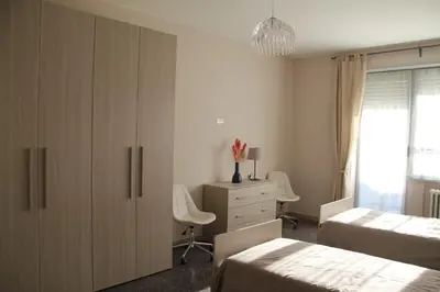 a bedroom with two beds and a cabinet and a dresser at Affittacamere Nansen in Rome