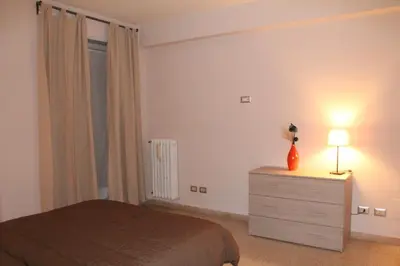 a bedroom with a bed and a dresser with a lamp at Affittacamere Nansen in Rome
