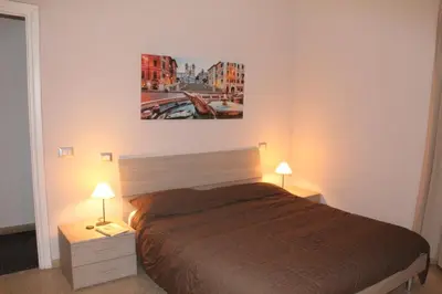 a bedroom with a bed with two lamps and a painting on the wall at Affittacamere Nansen in Rome