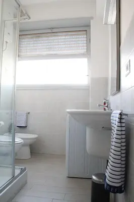 a bathroom with a sink and a toilet and a window at Affittacamere Nansen in Rome