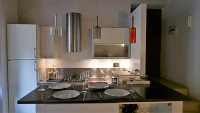 a kitchen with a counter with plates and wine glasses at Grotte Flat in Rome
