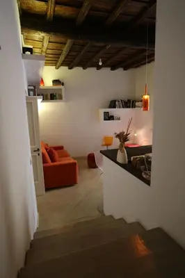 a living room with an orange couch and a staircase at Grotte Flat in Rome