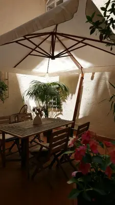 a table and chairs under a white umbrella at Grotte Flat in Rome