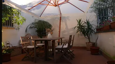a patio with a table and chairs and an umbrella at Grotte Flat in Rome