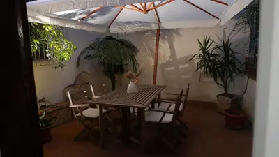 a dining room table with chairs and an umbrella at Grotte Flat in Rome