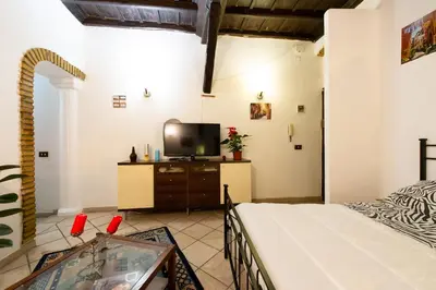 a bedroom with a bed and a tv in a room at JUSTACASA alla SCALA Trastevere in Rome