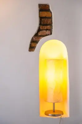 a yellow lamp on a wall next to a brick at JUSTACASA alla SCALA Trastevere in Rome