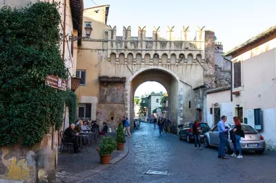 a group of people walking down a street with an arch at JUSTACASA alla SCALA Trastevere in Rome