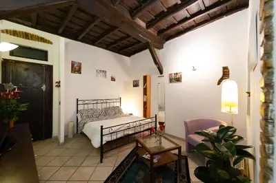 a bedroom with a bed and a table and a chair at JUSTACASA alla SCALA Trastevere in Rome