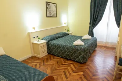 a bedroom with two beds and a wooden floor at Annette B&B in Rome