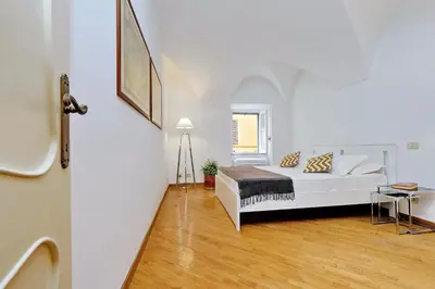 a bedroom with a bed in a white room at Clementina Charme - My Extra Home in Rome