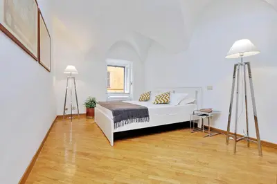 a white bedroom with a bed and two lamps at Clementina Charme - My Extra Home in Rome
