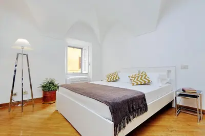 a white bedroom with a bed and a tripod at Clementina Charme - My Extra Home in Rome
