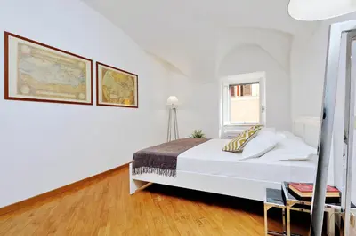 a white bedroom with a bed and a window at Clementina Charme - My Extra Home in Rome