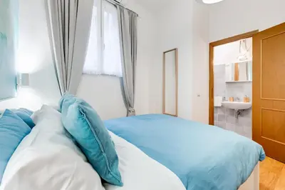 a bedroom with a bed with blue and white pillows at BDC - Opera Studio in Rome
