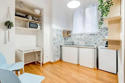 a small kitchen with white cabinets and a table at BDC - Opera Studio in Rome