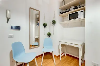 a small room with a desk and two chairs and a mirror at BDC - Opera Studio in Rome