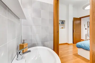 a bathroom with a sink and a bedroom at BDC - Opera Studio in Rome