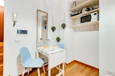 a small room with a white desk and blue chairs at BDC - Opera Studio in Rome